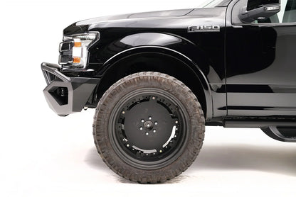 Fab Fours Vengeance front bumper with pre-runner guard on a black Ford F-150, close-up of the front corner, showing the pre-runner tube and bumper end cap