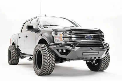 Fab Fours Vengeance front bumper with pre-runner guard on a black Ford F-150, front passenger-side three-quarter view, showing the pre-runner hoop, light bar and cube light pods