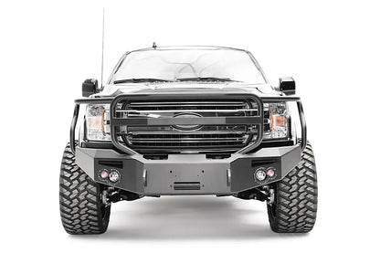Fab Fours Premium Winch front bumper with full guard on a black Ford F-150, straight-on front view, showing the full grille guard, winch recess and round fog lights