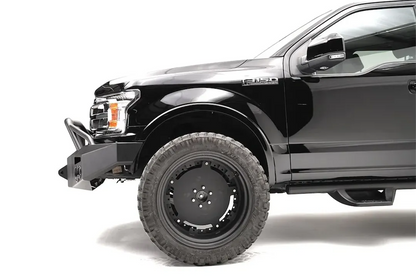 Fab Fours Premium Winch front bumper with pre-runner guard on a black Ford F-150, close-up of the front corner, showing the pre-runner tube, bumper end and wheel clearance