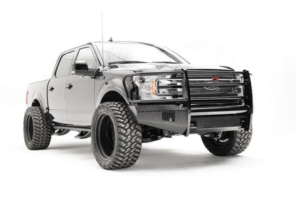 Fab Fours Black Steel front bumper with full guard on a black Ford F-150, front passenger-side three-quarter view, showing the full grille guard, diamond-plate face and bumper wings