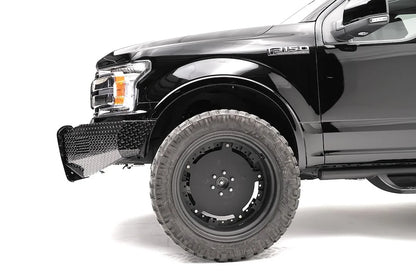 Fab Fours Black Steel front bumper on a black Ford F-150, close-up of the front corner, showing the diamond-plate bumper end and wheel clearance