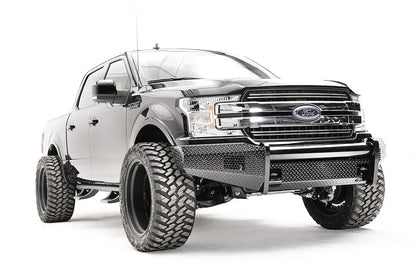 Fab Fours Black Steel front bumper on a black Ford F-150, front passenger-side three-quarter view, showing the diamond-plate face, tube top rail and bumper wings