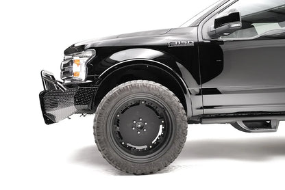 Fab Fours Black Steel front bumper with pre-runner guard on a black Ford F-150, close-up of the front corner, showing the pre-runner tube and diamond-plate bumper end