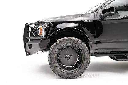 Fab Fours Black Steel Elite front bumper with full guard on a black Ford F-150, close-up of the front corner, showing the guard upright, bumper end and mesh vent