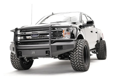 Fab Fours Black Steel Elite front bumper with full guard on a black Ford F-150, front driver-side three-quarter view, showing the full grille guard, smooth bumper face and mesh vents