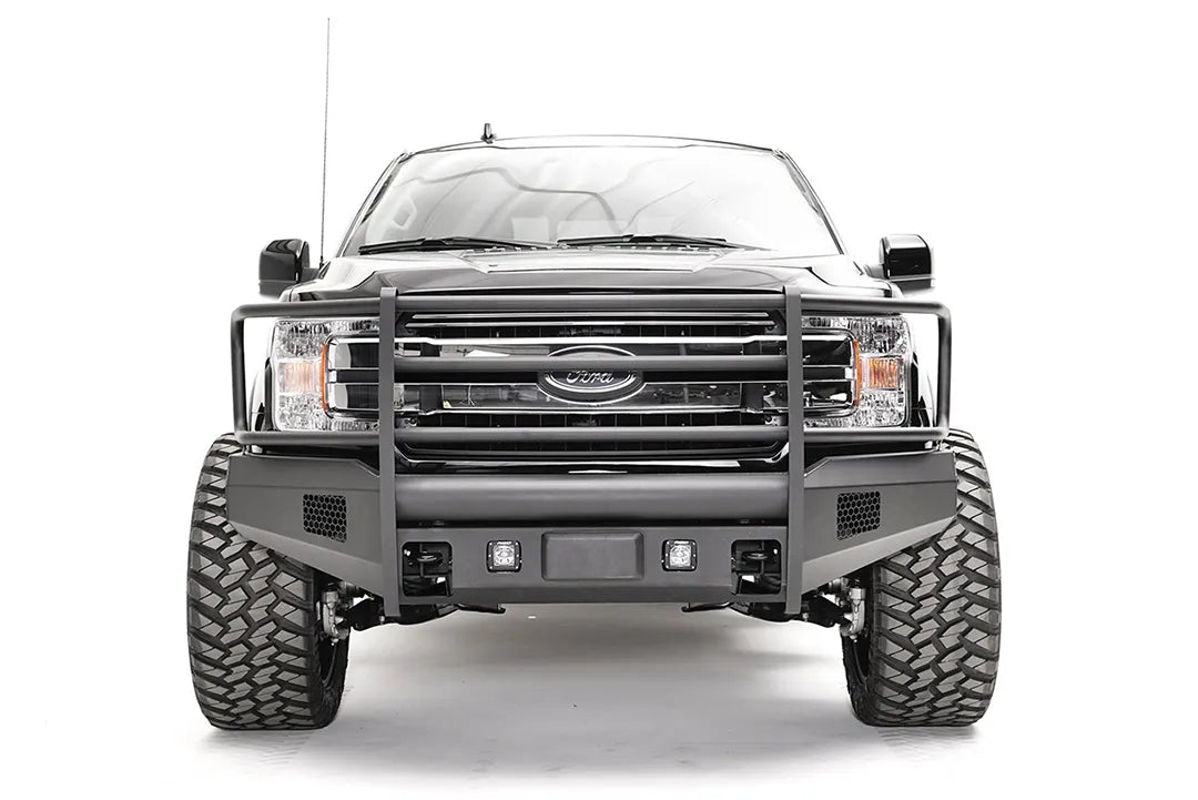 Fab Fours Black Steel Elite front bumper with full guard on a black Ford F-150, straight-on front view, showing the full grille guard, cube light openings and mesh vents