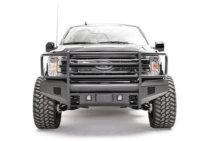 Fab Fours Black Steel Elite front bumper with full guard on a black Ford F-150, straight-on front view, showing the full grille guard, cube light openings and mesh vents