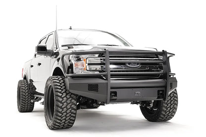 Fab Fours Black Steel Elite front bumper with full guard on a black Ford F-150, front passenger-side three-quarter view, showing the full grille guard, smooth bumper face and mesh vents