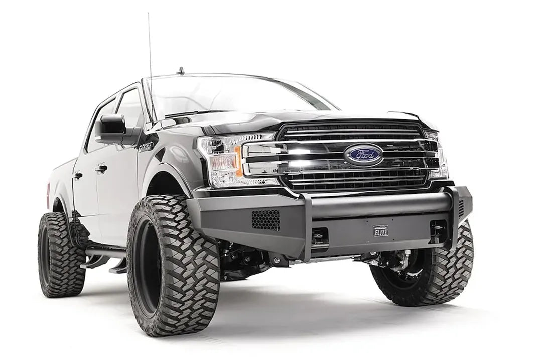 Fab Fours Black Steel Elite front bumper on a black Ford F-150, front passenger-side three-quarter view, showing the smooth bumper face, mesh vents and wrapped ends