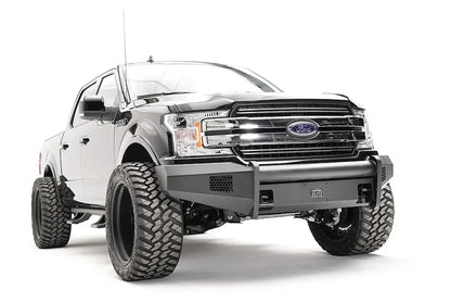 Fab Fours Black Steel Elite front bumper on a black Ford F-150, front passenger-side three-quarter view, showing the smooth bumper face, mesh vents and wrapped ends