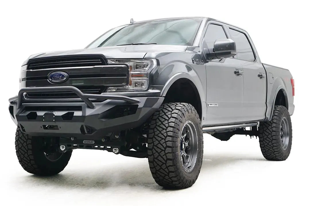 Fab Fours Matrix front bumper with pre-runner guard on a gray Ford F-150, front driver-side three-quarter view, showing the pre-runner hoop, winch fairlead and light cutouts