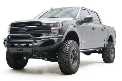 Fab Fours Matrix front bumper with pre-runner guard on a gray Ford F-150, front driver-side three-quarter view, showing the pre-runner hoop, winch fairlead and light cutouts