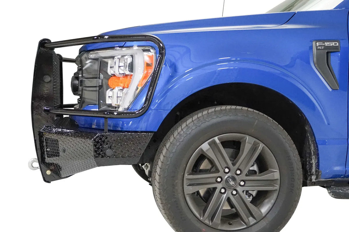 Fab Fours Black Steel front bumper with full guard on a blue Ford F-150, close-up of the front corner, showing the guard upright and diamond-plate bumper end
