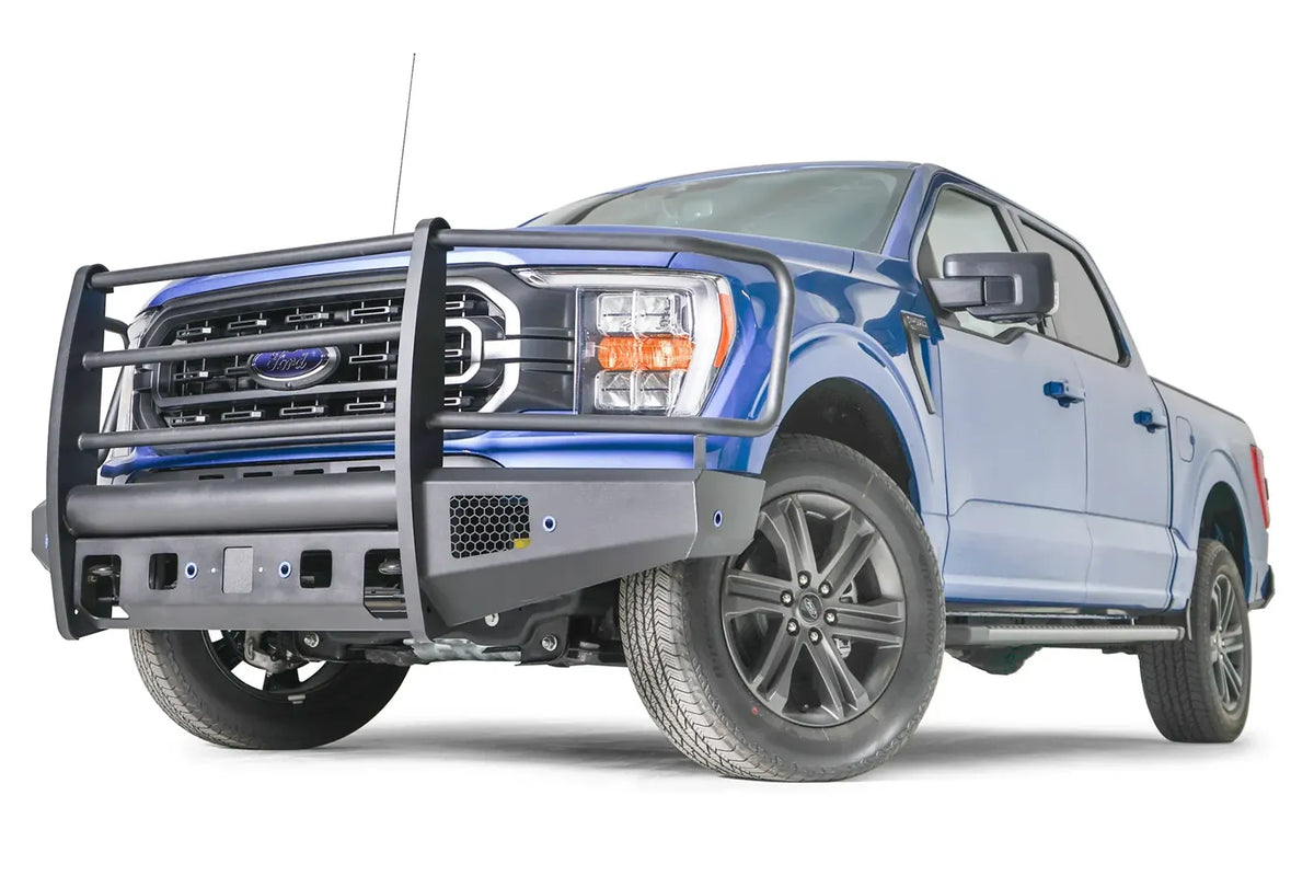 Fab Fours Black Steel Elite front bumper with full guard on a blue Ford F-150, front driver-side three-quarter view, showing the full grille guard, mesh vent and bumper end
