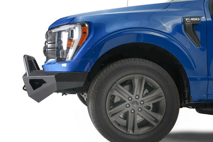 Fab Fours Red Steel front bumper with pre-runner guard on a blue Ford F-150, close-up of the front corner, showing the pre-runner tube and bumper end