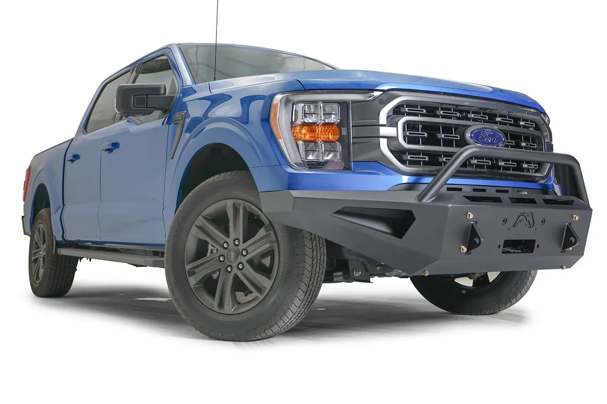 Fab Fours Red Steel front bumper with pre-runner guard on a blue Ford F-150, front passenger-side three-quarter view, showing the pre-runner hoop, shackle mounts and angled bumper wing