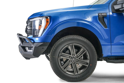 Fab Fours Vengeance front bumper with pre-runner guard on a blue Ford F-150, close-up of the front corner, showing the pre-runner tube and bumper end cap