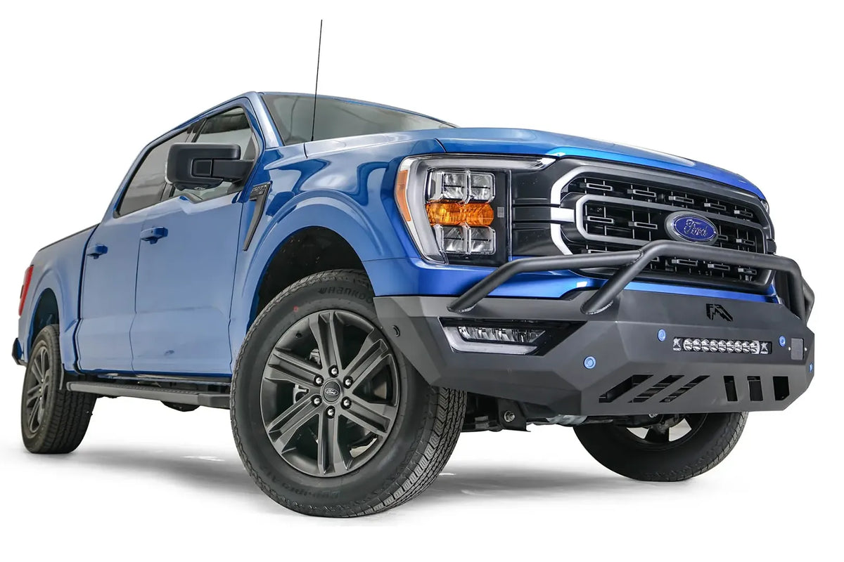 Fab Fours Vengeance front bumper with pre-runner guard on a blue Ford F-150, front passenger-side three-quarter view, showing the pre-runner hoop, light bar and angled end cap