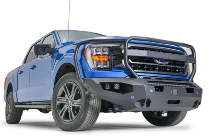 Fab Fours Matrix front bumper with full guard on a blue Ford F-150, front passenger-side three-quarter view, showing the full grille guard, cube light pods and angled end cap