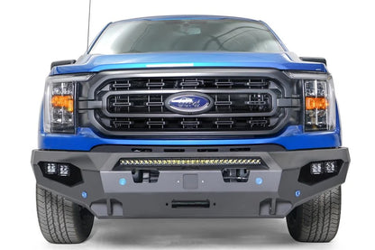 Fab Fours Matrix front bumper on a blue Ford F-150, straight-on front view, showing the center light bar, cube light pods and winch plate