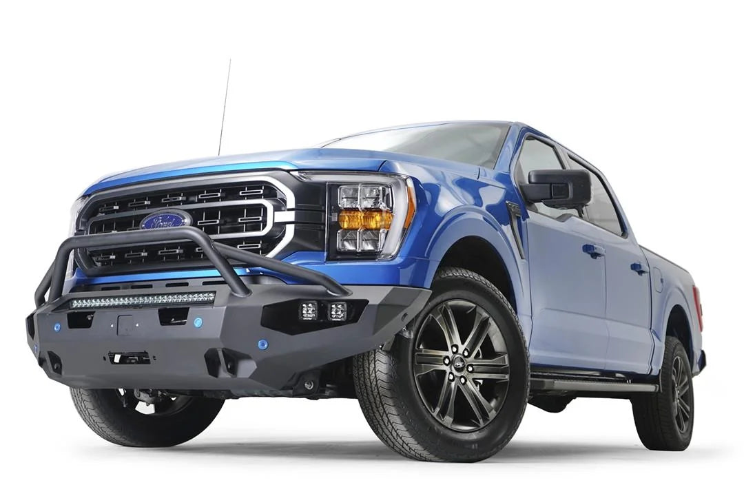 Fab Fours Matrix front bumper with pre-runner guard on a blue Ford F-150, front driver-side three-quarter view, showing the pre-runner hoop, light bar and cube light pods