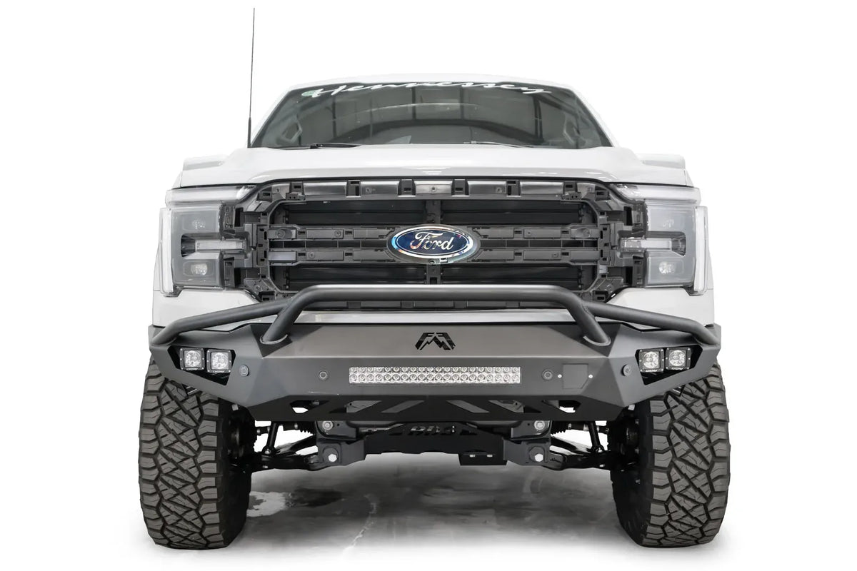 Fab Fours Vengeance front bumper with pre-runner guard on a white Ford F-150, straight-on front view, showing the pre-runner hoop, center light bar and cube light pods
