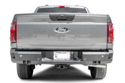 Fab Fours Premium rear bumper on a gray Ford F-150, straight-on rear view, showing the parking sensor cutouts, the center license plate recess and the hitch receiver access