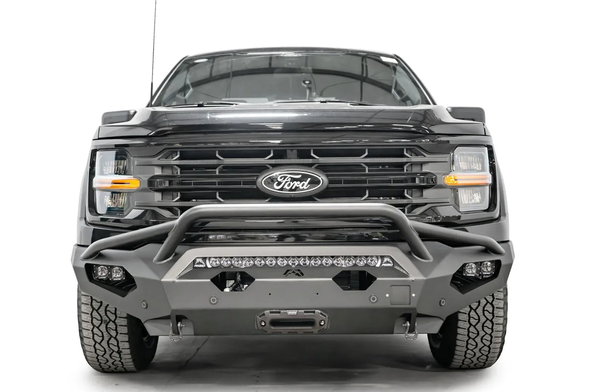 Fab Fours Matrix front bumper with pre-runner guard on a black Ford F-150, straight-on front view, showing the pre-runner hoop, center light bar and winch