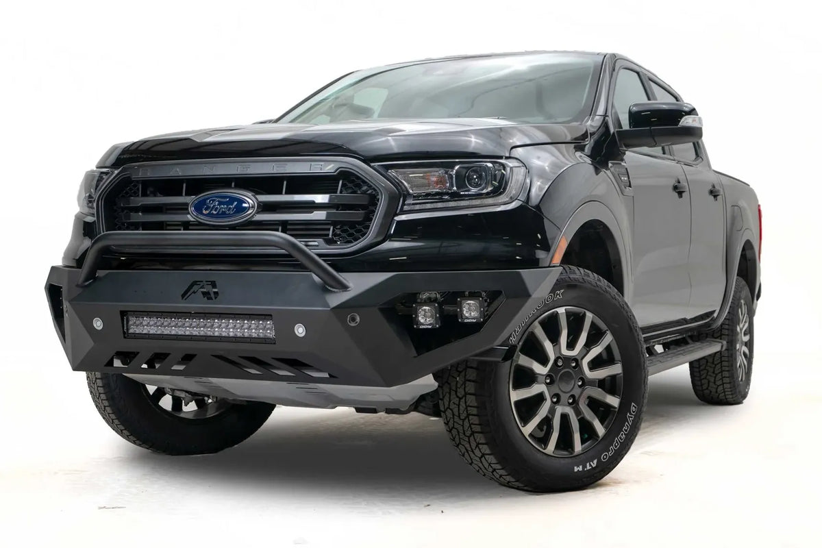 Fab Fours Vengeance front bumper with pre-runner guard on a black Ford Ranger, front driver-side three-quarter view, showing the pre-runner hoop, light bar and cube light pods