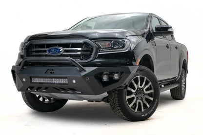 Fab Fours Vengeance front bumper with pre-runner guard on a black Ford Ranger, front driver-side three-quarter view, showing the pre-runner hoop, light bar and cube light pods
