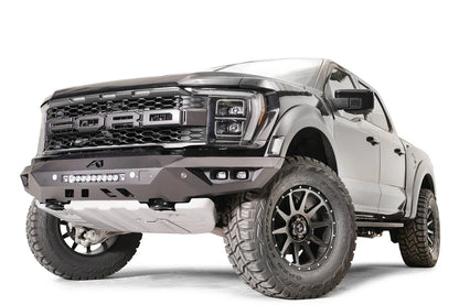 Fab Fours Vengeance front bumper on a black Ford Raptor, front driver-side three-quarter view, showing the light bar, cube light pods and angled end cap