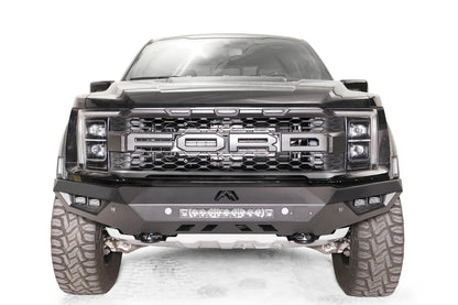 Fab Fours Vengeance front bumper on a black Ford Raptor, straight-on front view, showing the center light bar, cube light pods and skid plate