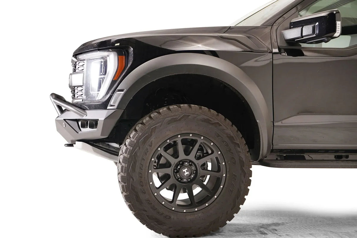 Fab Fours Vengeance front bumper with pre-runner guard on a dark gray Ford Raptor, close-up of the front corner, showing the pre-runner tube and bumper end cap