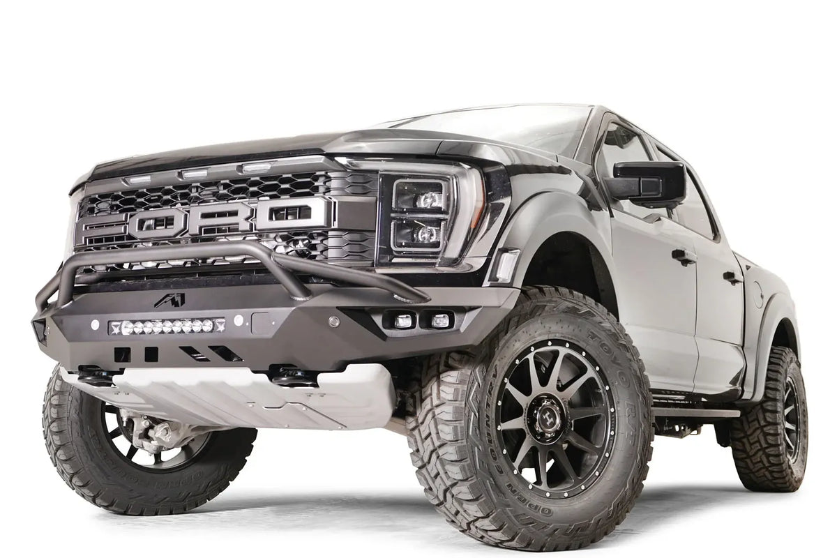 Fab Fours Vengeance front bumper with pre-runner guard on a dark gray Ford Raptor, front driver-side three-quarter view, showing the pre-runner hoop, light bar and angled end cap