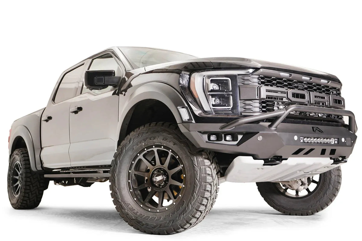 Fab Fours Vengeance front bumper with pre-runner guard on a dark gray Ford Raptor, front passenger-side three-quarter view, showing the pre-runner hoop, cube light pods and skid plate