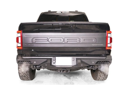Fab Fours Vengeance rear bumper on a dark gray Ford F-150 Raptor, straight-on rear view, showing the full-width bumper, integrated corner lights and center hitch receiver opening