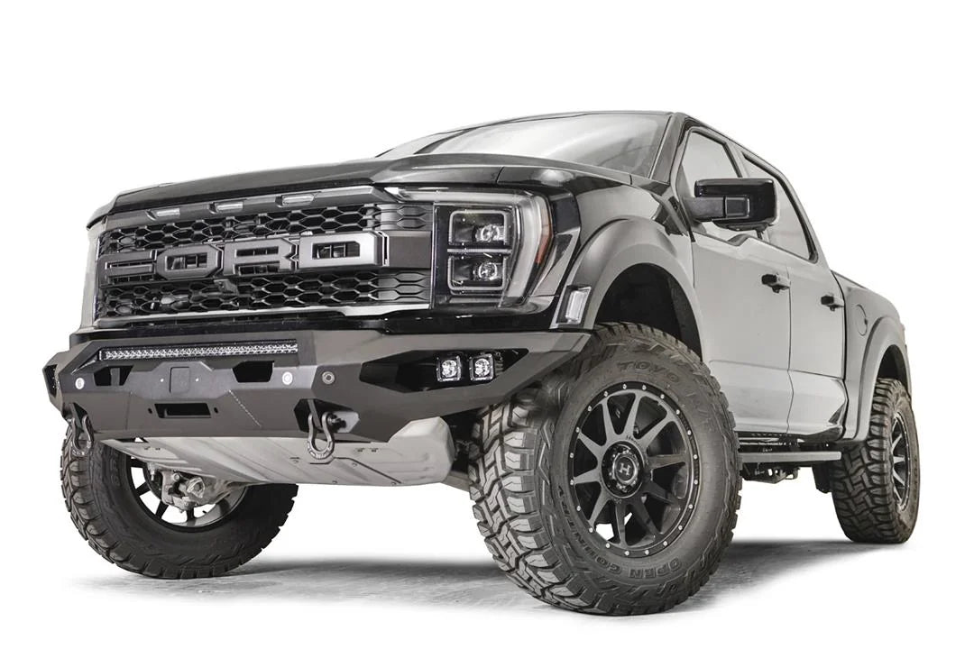 Fab Fours Matrix front bumper on a gray Ford F-150 Raptor, front driver-side three-quarter view, showing the center light bar, pod light cutouts and D-ring shackle mounts