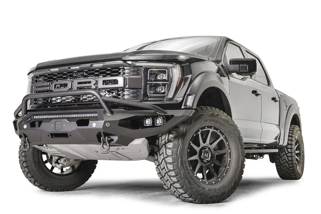 Fab Fours Matrix front winch bumper with pre-runner guard on a gray Ford F-150 Raptor, front driver-side three-quarter view, showing the pre-runner hoop, light bar and D-ring shackle mounts