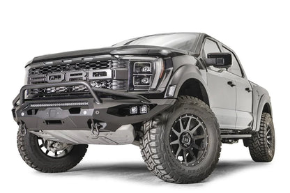Fab Fours Matrix front winch bumper with pre-runner guard on a gray Ford F-150 Raptor, front driver-side three-quarter view, showing the pre-runner hoop, light bar and D-ring shackle mounts