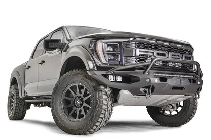 Fab Fours Matrix front winch bumper with pre-runner guard on a gray Ford F-150 Raptor, front passenger-side three-quarter view, showing the tubular pre-runner hoop, center light bar and pod lights