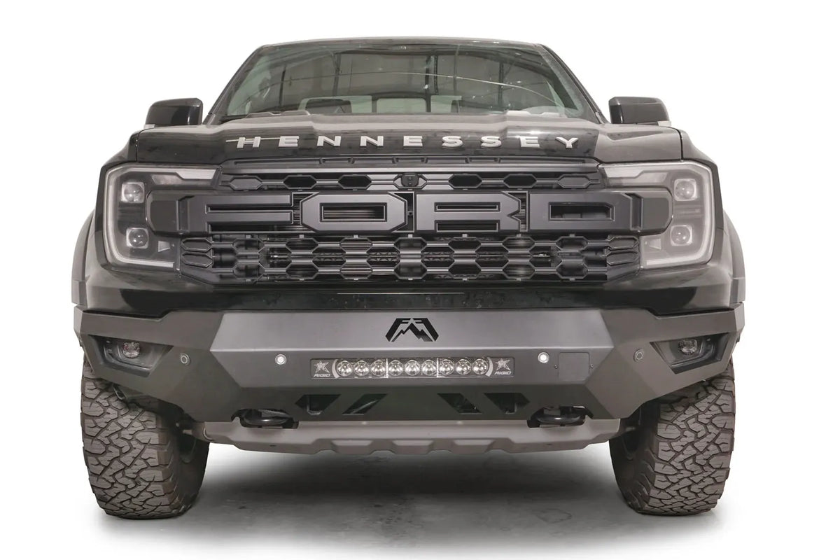 Fab Fours Vengeance front bumper on a gray Ford Ranger Raptor, straight-on front view, showing the center light bar, Fab Fours logo cutout and angular skid section