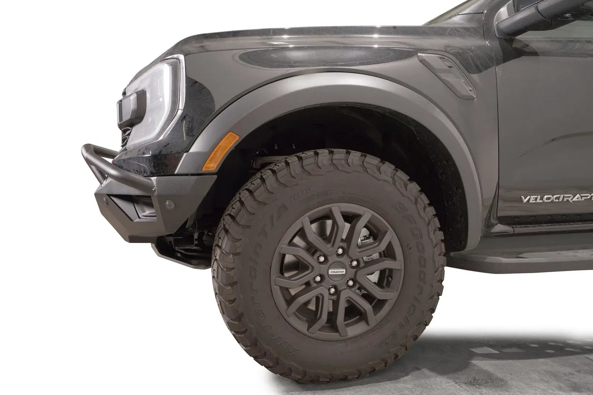 Fab Fours Vengeance front bumper with pre-runner guard on a gray Ford Ranger Raptor, close-up of the front corner, showing the pre-runner tube end, bumper wing and wheel clearance