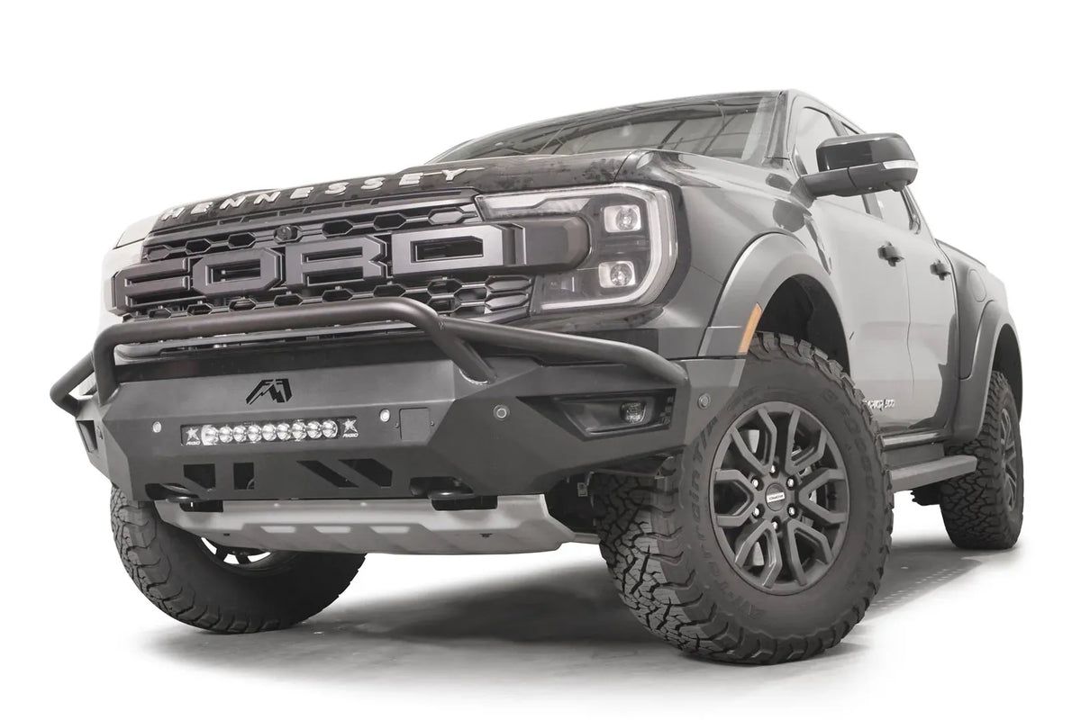 Fab Fours Vengeance front bumper with pre-runner guard on a gray Ford Ranger Raptor, front three-quarter view, showing the pre-runner hoop, center light bar and bumper end cap