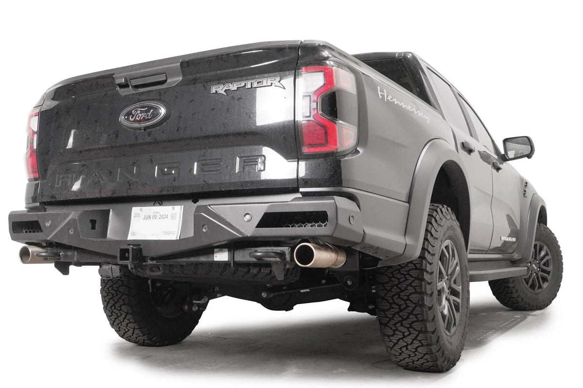 Fab Fours Vengeance rear bumper with honeycomb mesh light openings and parking sensors on a dark gray Ford Ranger Raptor, passenger-side rear three-quarter view