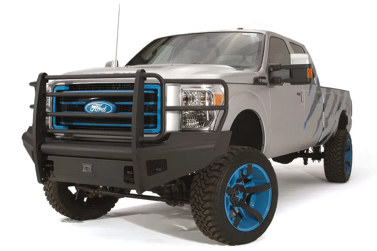 Fab Fours Black Steel Elite front bumper with full guard on a silver Ford Super Duty, front driver-side three-quarter view, showing the full tubular grille guard, smooth plate face and bumper wing