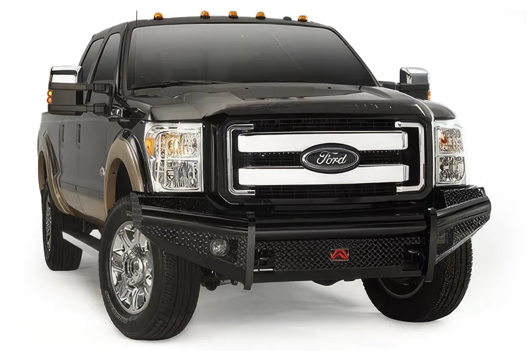Fab Fours Black Steel front ranch bumper on a black and tan Ford Super Duty, front three-quarter view, showing the diamond-plate face, wraparound wings and center logo plate