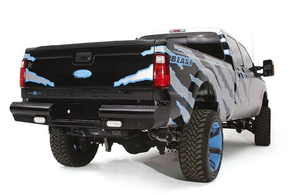 Fab Fours Black Steel ranch rear bumper on a black and silver Ford Super Duty, rear passenger-side three-quarter view, showing the diamond-plate step, wraparound end cap and integrated lights