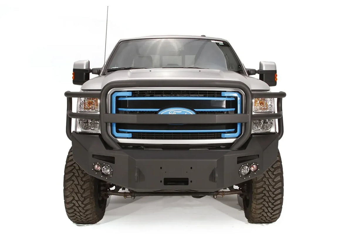 Fab Fours Premium Heavy Duty winch front bumper with full guard on a silver Ford Super Duty, straight-on front view, showing the full grille guard, winch opening and pair of integrated lights