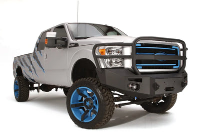 Fab Fours Premium Heavy Duty winch front bumper with full guard on a silver Ford Super Duty, front passenger-side three-quarter view, showing the full grille guard, headlight hoops and integrated lights